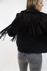 Campera marrón de gamuza sintética con flecos colgantes en la espalda y mangas, solapas anchas y cierre frontal.