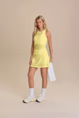 Pollera deportiva amarilla de tejido calado, con short interior incorporado.