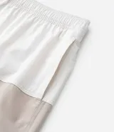 Bermuda de baño de microfibra con diseño bicolor, cintura elástica con cordón ajustable, bolsillos laterales y bolsillo trasero con cierre.