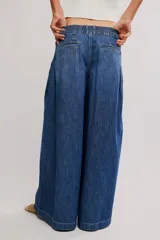 Pantalón de denim celeste de tiro bajo, pierna muy ancha y diseño sastrero con tablas al frente. Cuenta con cintura fruncida en la espalda, bolsillos y cierre frontal con cremallera y gancho.