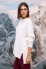 Buzo oversize de tejido de punto con textura acanalada, color blanco, de cuello redondo, manga larga y tajos laterales en el ruedo.