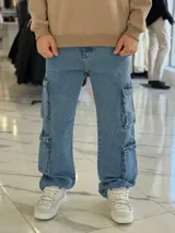Pantalón cargo de jean azul claro, con corte oversize y múltiples bolsillos laterales en las piernas.