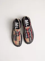 Mocasines con plataforma de goma negra, confeccionados en lona con estampa a cuadros en tonos violeta, amarillo y beige, y detalle de elásticos laterales ocultos.