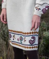 Falda midi de tejido de punto color blanco marfil, confeccionada en lana merino, con diseño bordado a mano de motivos paisley y guardas geométricas en tonos marrones y celestes. Cuenta con cintura elástica.