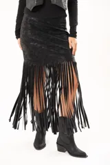 Pollera midi de cuerina negra con diseño ajustado en la parte superior y terminación en flecos largos que aportan movimiento.