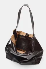 Bolso maxi shopper color marrón oscuro de cuero sintético con asa ancha ajustable con hebilla dorada. Tiene bolsillo interno con cierre y cierre imantado.