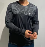 Remera de manga larga color negro, con panel superior estampado en gris con diseño de líneas abstractas y logo de la marca en el pecho.