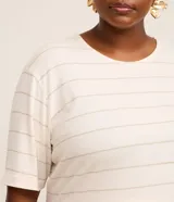 Remera de viscolycra color crema con rayas horizontales doradas, cuello redondo y mangas cortas.