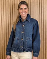 Sobrecamisa de denim azul con cierre frontal de botones grandes, bolsillos frontales plaqué con solapa y detalle de volado en el ruedo.