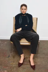 Zapato de tacón tipo destalonado confeccionado en piel con acabado brillante. Presenta diseño de punta fina, pespuntes decorativos en el empeine y tira trasera con elástico lateral. Incluye tacón kitten fino.