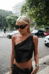 Top color crema de cuero sintético, con un solo tirante ancho y corte asimétrico.