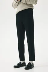 Pantalón de vestir negro, corte slim fit, con cierre y botón frontal, bolsillos laterales y bolsillos insertados traseros con botón. Presenta raya marcada en las piernas.