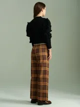 Cardigan negro de algodón con cierre frontal doble, cuello a la base y mangas tipo jamón con bordados en ochos y apliques de pompones. Presenta terminaciones acanaladas en contraste en cuello, puños y ruedo.