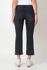 Pantalón de jean negro con corte cropped flare y cierre frontal con botones.