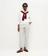 Pantalón de corte carrot con cintura alta, confeccionado en sarga de algodón con estampado de rayas verticales. Presenta un diseño holgado en la cadera que se estrecha hacia el tobillo, con bolsillos laterales y cierre frontal.