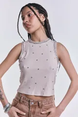 Musculosa de morley color beige, sin mangas, con apliques de strass y tachas en el cuello y distribuidos por toda la prenda.