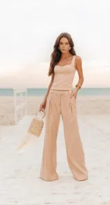 Conjunto de dos piezas en color beige, compuesto por un top de escote cuadrado con tirantes anchos y un pantalón de corte sastrero con pinzas, tiro alto y pernera ancha.