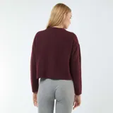 Cárdigan color borgoña de tejido de punto, corte cropped, con cuello redondo, cierre frontal con botones y bolsillos de parche.