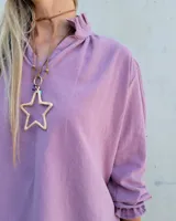 Blusa de algodón con cuello mao y volados, mangas largas con puños elásticos y corte holgado.