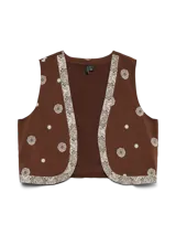 Chaleco sin mangas de corte recto, color marrón con estampado de pequeños motivos circulares y bordes decorativos en tono claro. Presenta un diseño abierto al frente, ideal para combinar en capas.