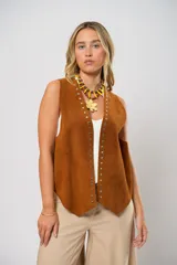 Chaleco marrón de cuero descarne con terminación en picos, tachas metálicas y flecos en la espalda.
