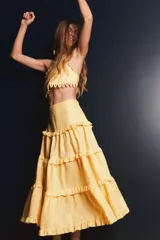 Falda larga color amarillo pálido, de lino, con cintura elastizada y corte escalonado con volados.