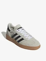 Championes Adidas Handball Spezial color crema con las tres tiras laterales en negro y suela de goma marrón.