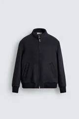 Cazadora de corte regular fit confeccionada en tejido de mezcla de lana y cashmere. Presenta cuello subido con cierre de botones, cierre frontal con cremallera de doble dirección, bolsillos laterales de vivo y acabados en rib de punto en puños y cintura.