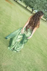 Pantalón de estilo bombacho en color verde esmeralda con acabado satinado. Presenta una cintura alta con detalle de fruncido lateral y un corte amplio y voluminoso en las piernas que se ajusta en los tobillos.