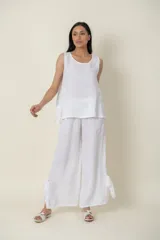 Pantalón palazzo blanco de lino italiano, con cintura elastizada y lazos de seda en los tobillos.