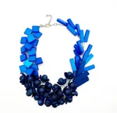 Collar corto de resina azul con piezas geométricas y esféricas.