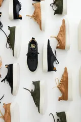 Zapatillas de gamuza verde oliva con cordones marrones y suela de goma color crema.