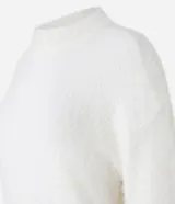 Suéter de punto color crema con cuello redondo y mangas largas ajustadas. Modelo slim alargado con efecto de pelitos.