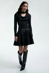 Remera de manga larga en punto elástico, color negro con estampado de lunares pequeños en color blanco. Presenta un diseño entallado con cuello drapeado y una tira lateral decorativa.