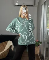 Sweater de tejido de punto con diseño abstracto de líneas blancas sobre fondo de color sólido. Presenta un corte clásico y textura suave.