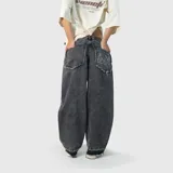 Pantalón de jean estilo baggy, color negro con efecto lavado. Presenta un corte extremadamente holgado, bolsillos traseros con bordes deshilachados y un diseño de llamas bordado en uno de los bolsillos traseros.