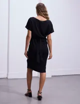 Vestido midi negro de crepe con escote a la base, mangas cortas japonesas, corte en la cintura elastizada con lazo de ajuste y tajo en la delantera.
