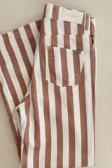 Pantalón jean de tiro bajo con estampado a rayas verticales color marrón y blanco.