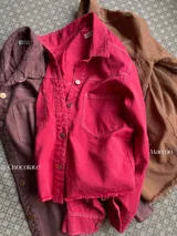 Camisa de denim celeste claro, de corte holgado, con cuello clásico, cierre frontal con botones a presión y bolsillos con solapa en el pecho.