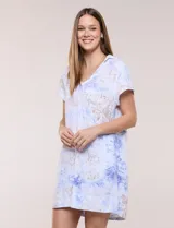 Vestido corto de lino color celeste con cuello camisero, escote en V, mangas cortas, bolsillos laterales invisibles y silueta holgada.