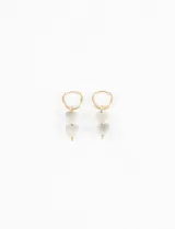 Aros tipo argolla de cobre dorado con tres dijes colgantes en forma de corazón hechos de piedra natural grisácea.