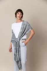 Chal de hilo artesanal color verde con detalles en gris y blanco, con flecos en los extremos y presilla para sujetarlo.