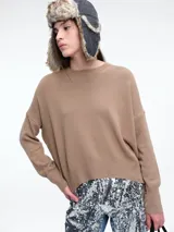 Sweater de punto color negro, con cuello redondo, hombros caídos y terminaciones acanaladas en puños y ruedo. Presenta un diseño de calce relajado y tejido suave.
