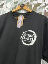 Remera negra de manga corta con estampado frontal del logo de Demon Slayer en color blanco.