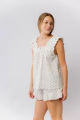 Pijama de algodón estampado, compuesto por una musculosa con escote recto fruncido y breteles con volados, y un short con cintura elástica y terminación con volado en el ruedo.