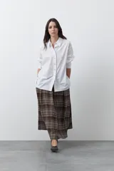 Camisa de corte relajado y diseño clásico, confeccionada en tela de algodón color celeste. Presenta cuello tradicional, cierre frontal con botones y mangas largas con puños rectos.