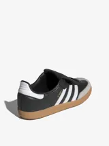 Zapatillas Adidas Samba LT, color negro con las tres tiras blancas y suela de goma marrón.