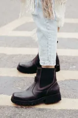 Bota tipo chelsea de cuero color marrón oscuro, con paneles laterales elásticos y suela track robusta con plataforma.