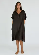 Vestido midi de lino color beige, con cuello en V, cierre frontal parcial con botones y mangas cortas con dobladillo.