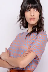 Top de manga corta, ajustado al cuerpo y con escote redondo, confeccionado con un estampado retro en tonos celestes y naranjas.